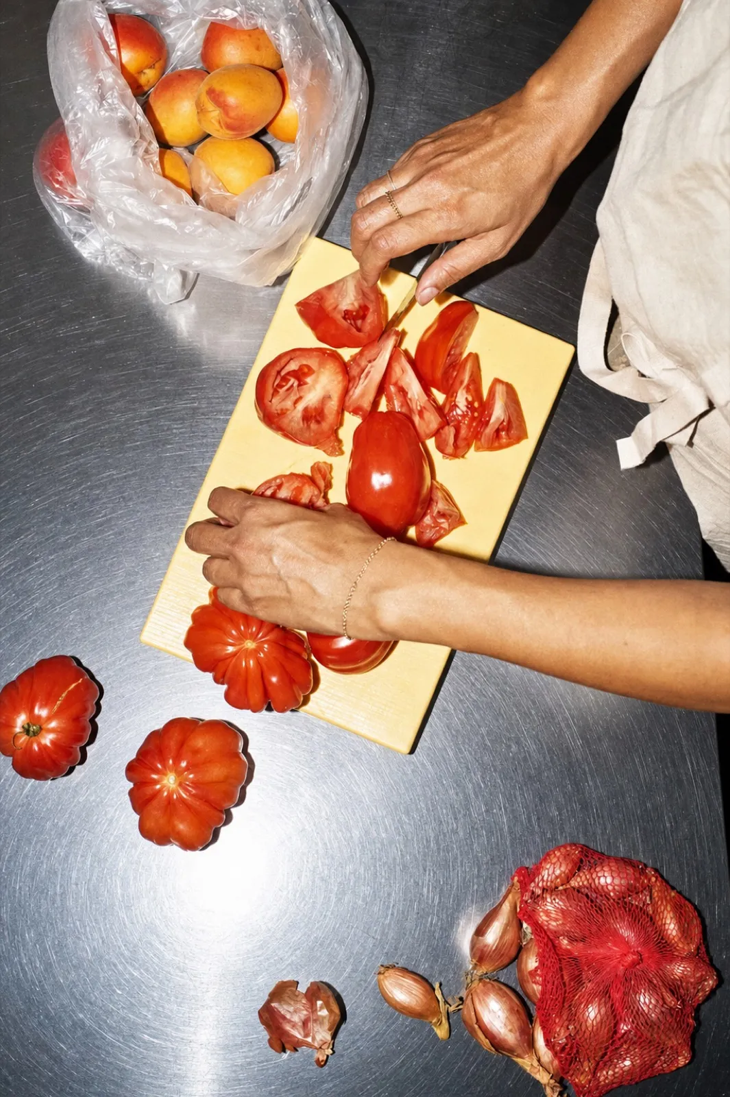Tomaten und Schalotten werden auf einem Brett geschnitten